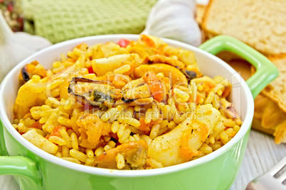 Pilaf with seafood and bread on board