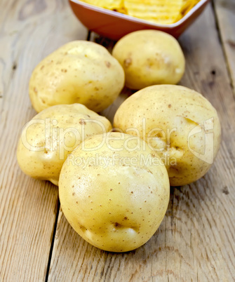 Potatoes yellow and chips on wooden board