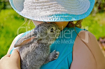 Rabbit gray on hands of girl in hat