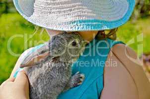 Rabbit gray on hands of girl in hat