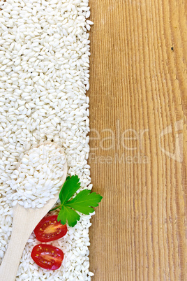 Rice white with spoon and tomatoes on board
