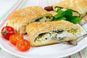 Roll filled with spinach and cheese in bowl on tablecloth