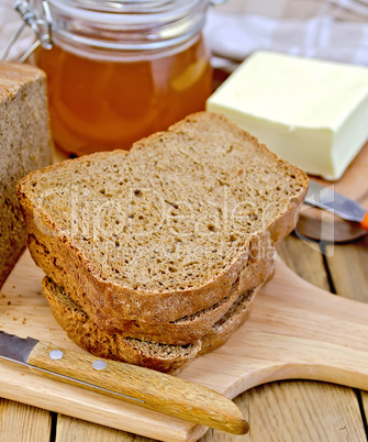 Rye homemade bread with honey and butter on board