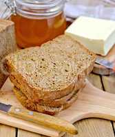 Rye homemade bread with honey and butter on board