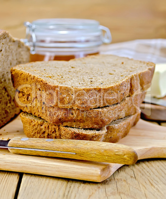 Rye homemade bread with honey and knife on board