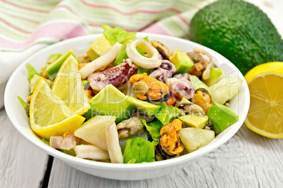 Salad seafood and lemon on white board