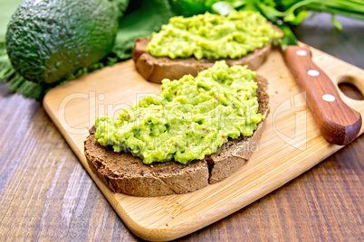 Sandwich with avocado guacamole on board