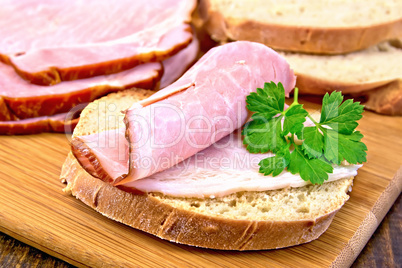 Sandwich with ham and parsley on board