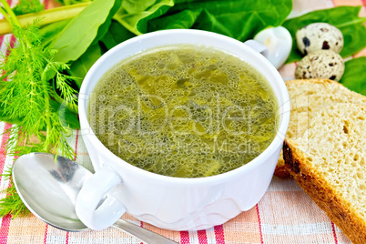 Soup of greenery with bread on cloth