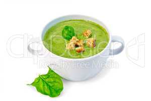 Soup puree with croutons and spinach leaves in bowl