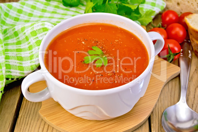 Soup tomato in bowl with spoon on board