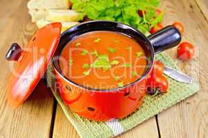 Soup tomato in red ware on board