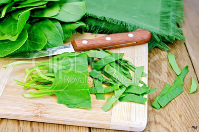 Spinach shredded with knife on board