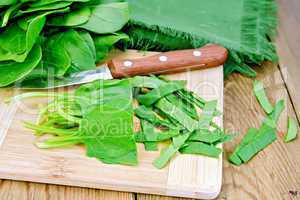 Spinach shredded with knife on board