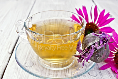 Tea Echinacea in glass cup with strainer on board