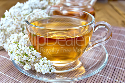 Tea with yarrow in cup on bamboo napkin