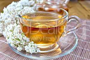 Tea with yarrow in cup on bamboo napkin