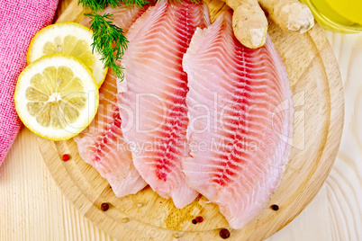 Tilapia with parsley and lemon on light board