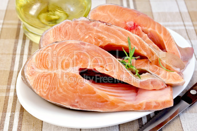 Trout in plate with rosemary and oil on napkin