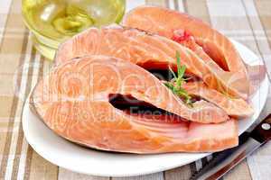 Trout in plate with rosemary and oil on napkin