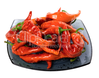Wet red chili peppers on glass plate