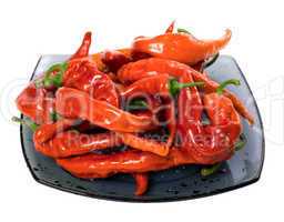 Wet red chili peppers on glass plate