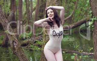 Woman Wearing Body Suit Posing Against Tree