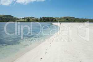 Lone Person Walking on Shore of White Sand Beach