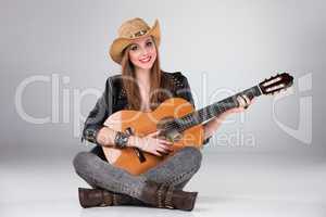 The beautiful girl in a cowboy's hat and acoustic guitar.