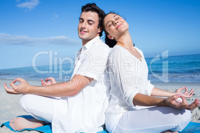 Happy couple doing yoga beside the water Happy couple doing yoga beside the water