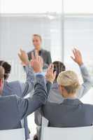 Business team raising hands during conference