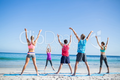 Friends doing yoga together with their teacher