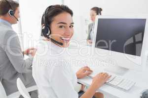 Business team working on computers and wearing headsets