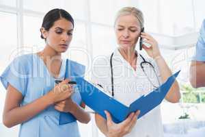 Doctor holding folder and having phone call