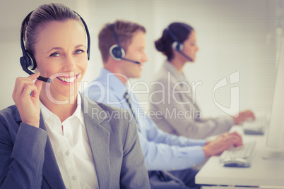 Business team working on computers and wearing headsets