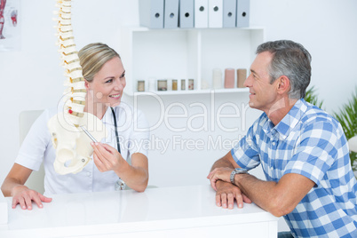 Doctor showing her patient a spine model