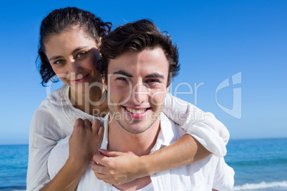 Handsome man giving piggy back to his girlfriend