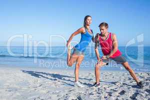 Happy couple stretching together beside the water