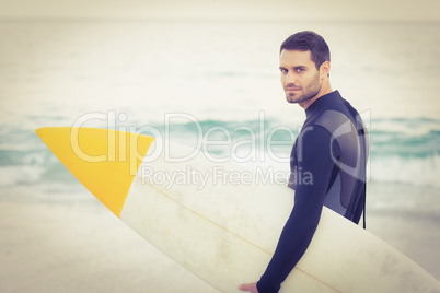 Man in wetsuit with a surfboard on a sunny day