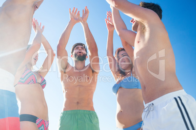 Group of friends standing in circle arms raised