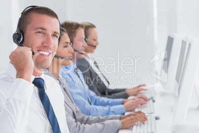 Business team working on computers and wearing headsets