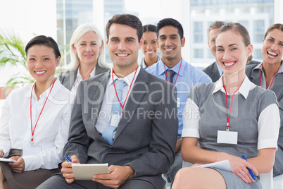 Smiling business people looking at camera during meeting