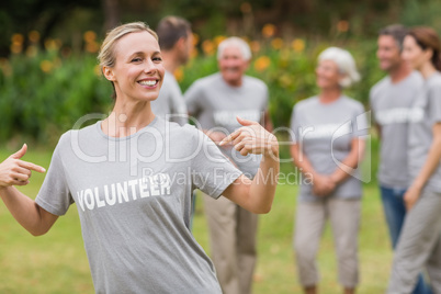 Happy volunteer showing her t-shirt to camera