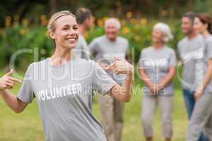 Happy volunteer showing her t-shirt to camera