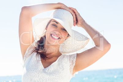 Pretty brunette wearing sunhat and looking at camera