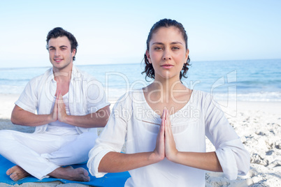 Happy couple doing yoga beside the water Happy couple doing yoga beside the water