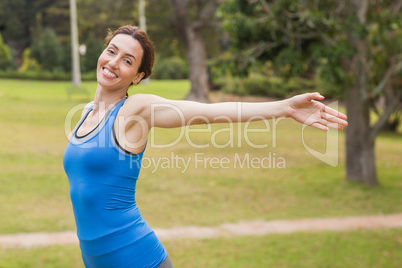 Pretty  brunette stretching her arms during jogging