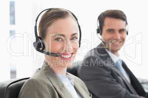 Business people with headsets smiling at camera