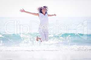 Carefree woman jumping on the beach
