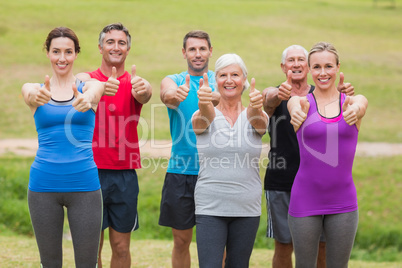 Happy athletic group smiling at camera with thumbs up